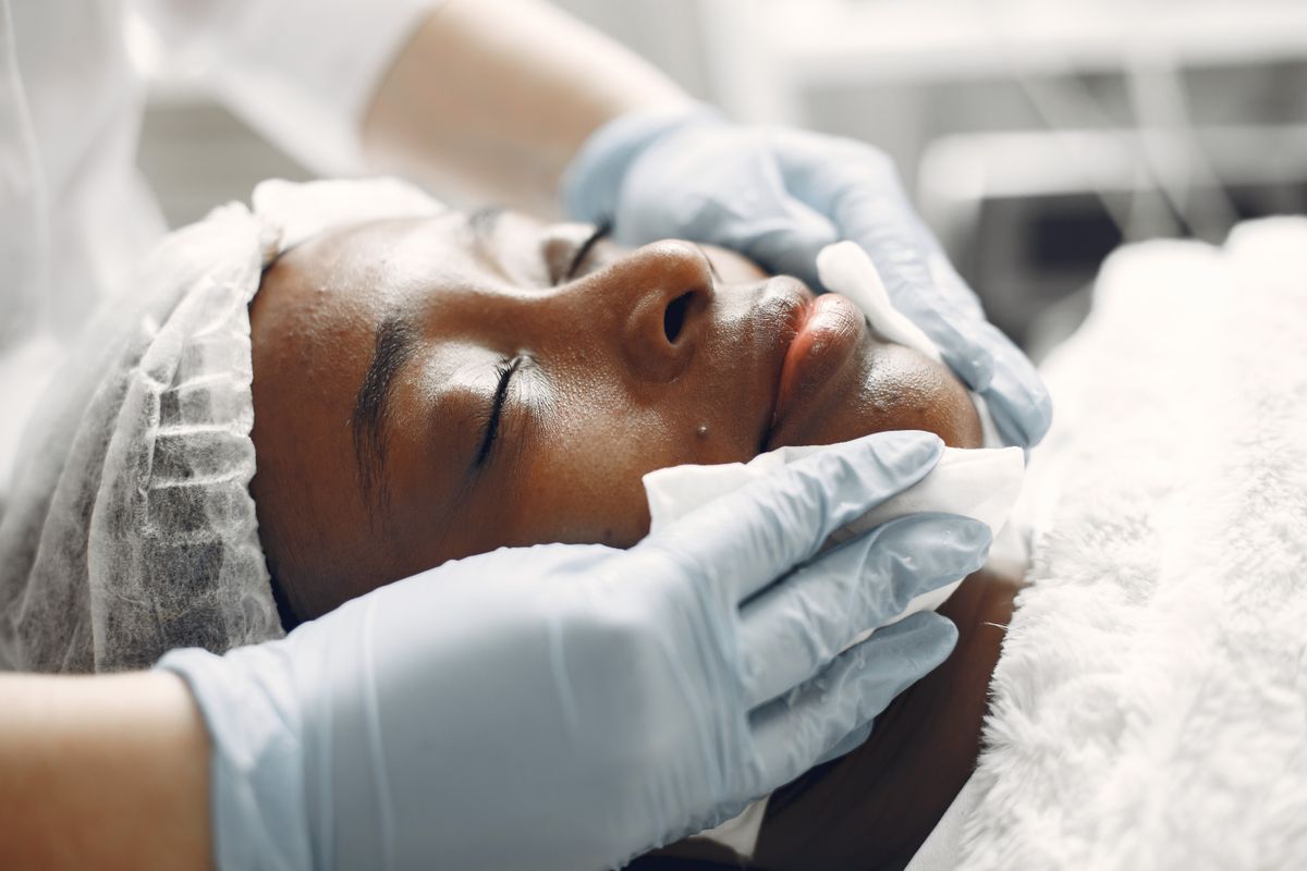 A dermatologist examining a patient's facial skin during a consultation