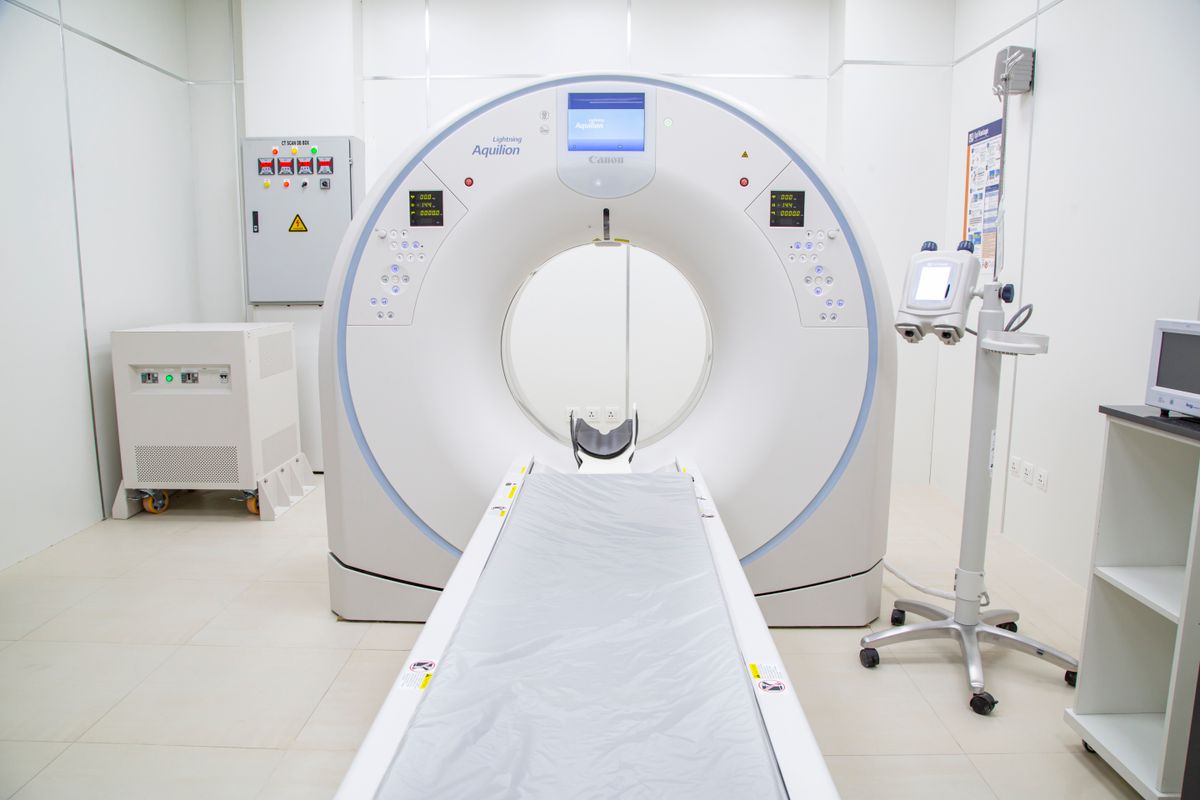 A patient entering an MRI scanner machine in a bright radiology suite